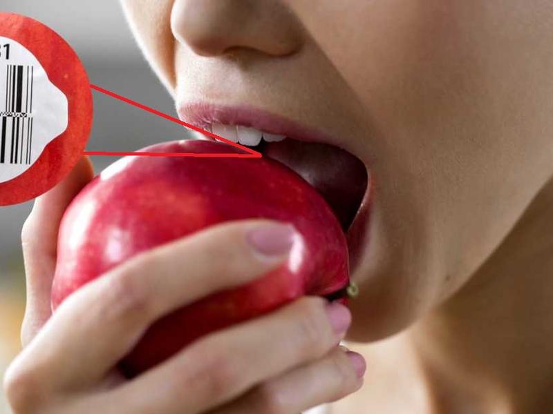 Mujer come una manzana justo donde está la etiqueta.