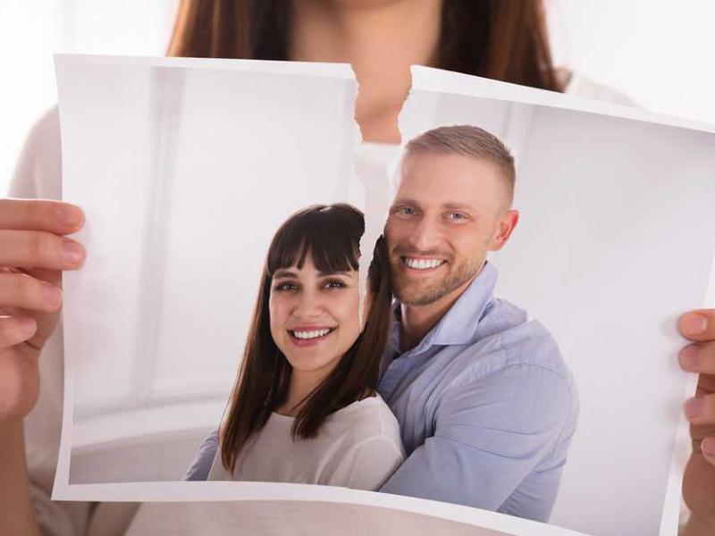 Mujer rompiendo una foto de ella y su pareja por rompimiento
