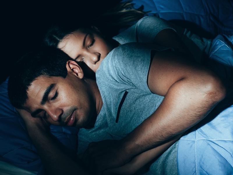 Mujer abraza a su pareja al dormir