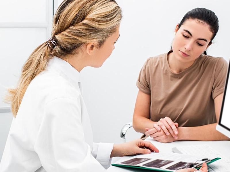 Mujer en consulta ginecológica al lado de una doctora. Foto: iStock