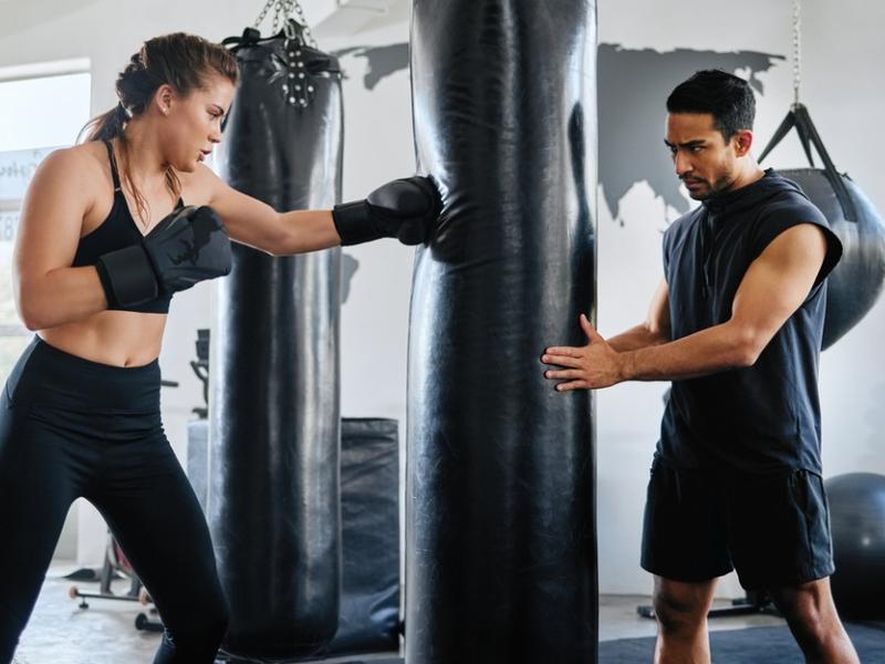 Mujer tomando clases de box ya conoce los beneficios del entrenamiento.