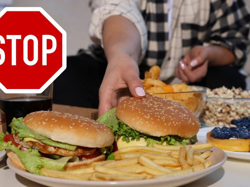 Mujer toma hamburguesa para comer signo de stop