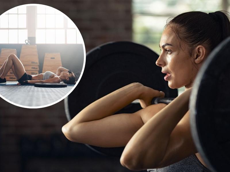 Mujer levanta barra con pesa descansa en tapete de ejercicio