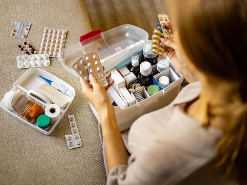 Mujer viendo los medicamentos que va a incluir en su botiquín de primeros auxilios