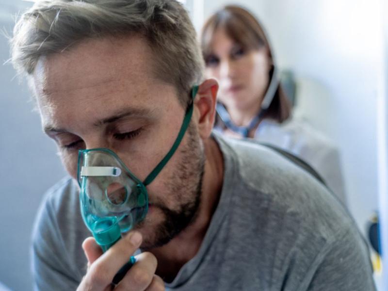 Hombre con mascarilla de oxigeno daño pulmonar