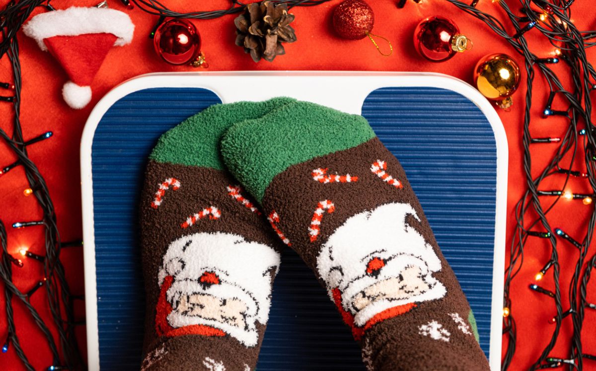 Calcetas navideñas tapando báscula para explicar qué hacer para no subir de peso en navidad