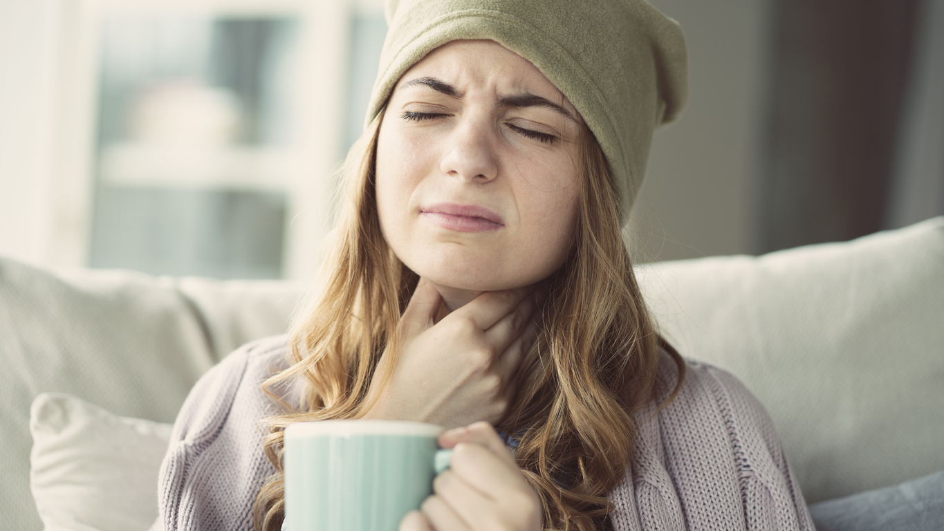 Mujer con dolor de garganta a causa de una gripe