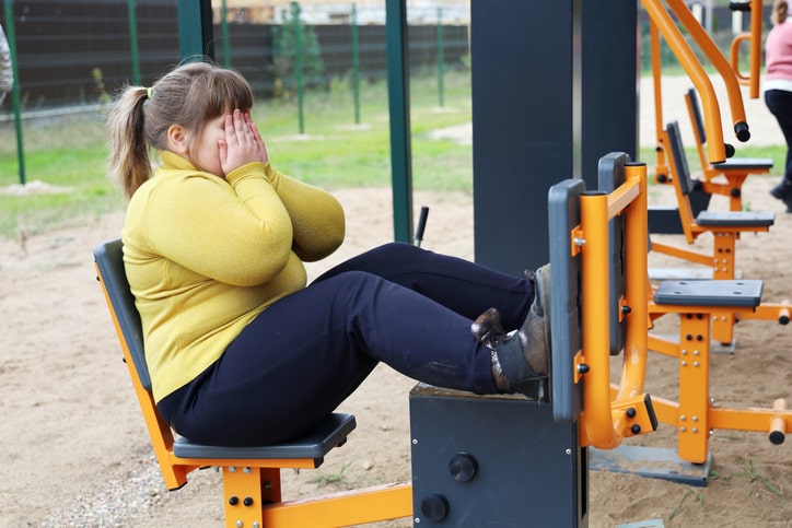 Niña con obesidad en máquinas de ejercicio