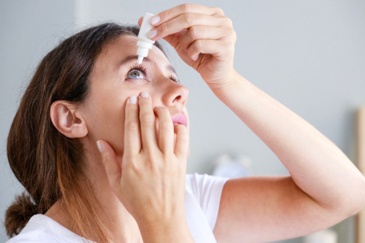 Mujer echando gotas de ojos para aliviar el ojo seco