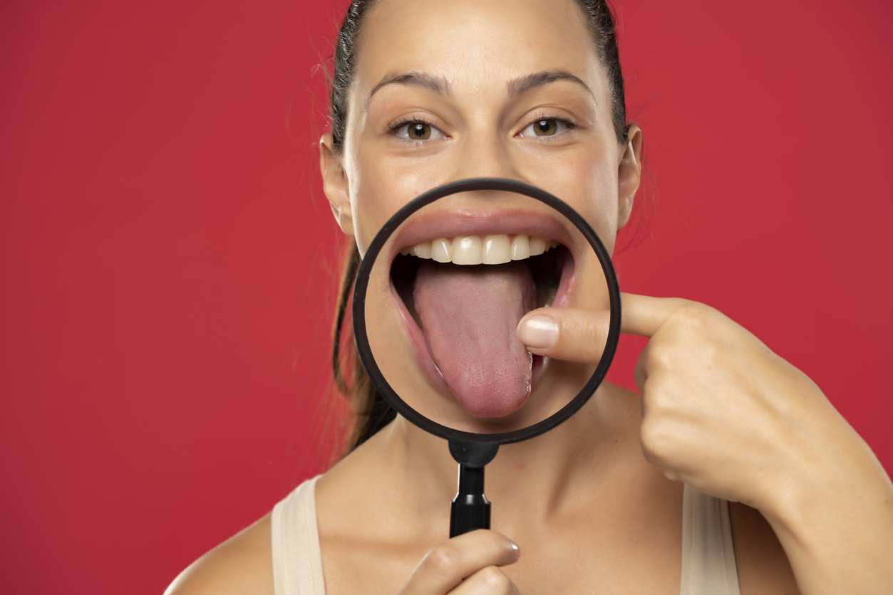 Mujer mostrando su lengua con lupa