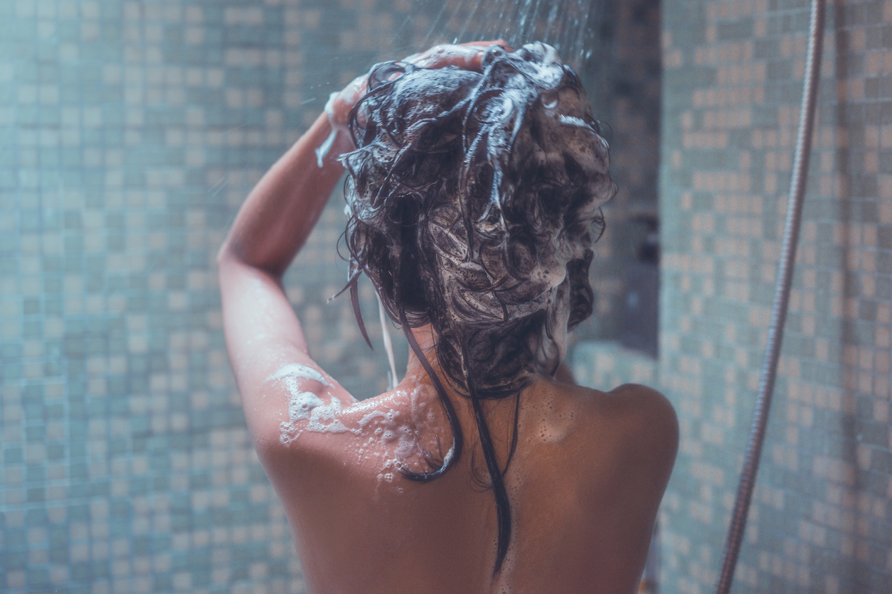 Mujer lavando su cabello con shampoo clarificante