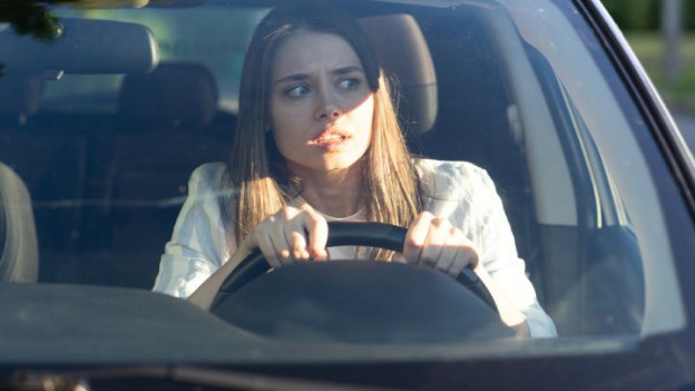 Mujer con estrés y miedo en el coche