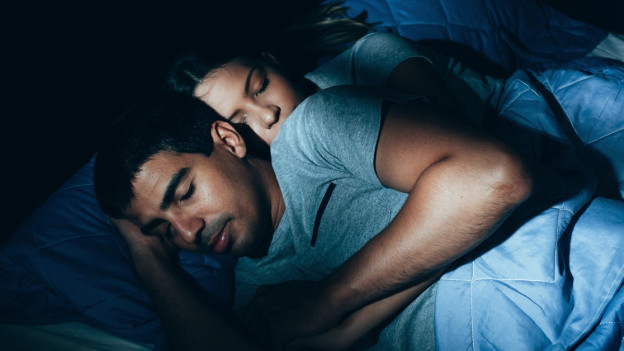 Mujer abraza a su pareja al dormir