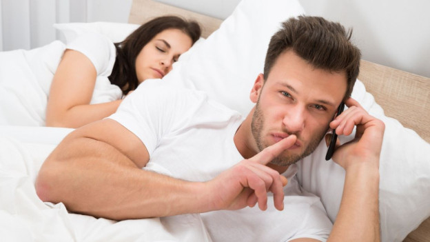 Hombre infiel en la cama con su pareja