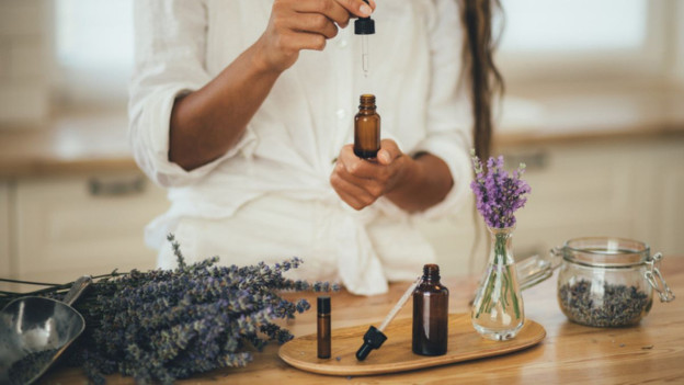 Mujer usando lavanda para crear un botiquín de aromaterapia