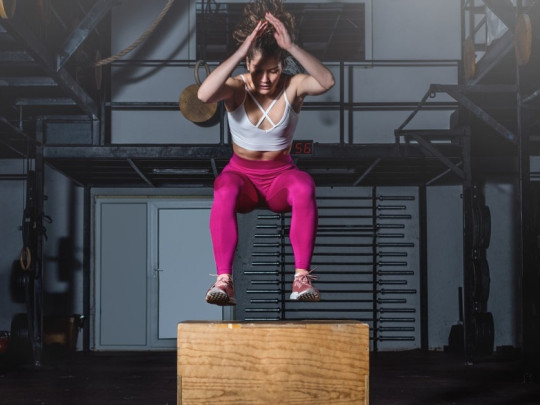 Mujer realizando rutina de CrossFit sobre una caja.