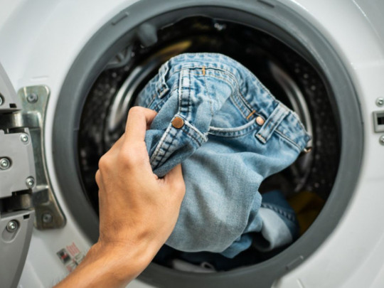 Persona lava ropa en lavadora 
