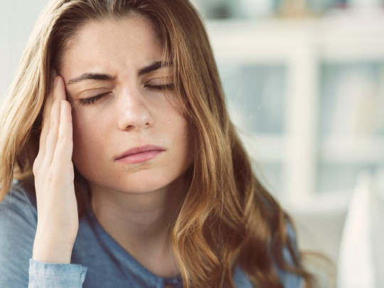 Mujer con dolor de cabeza por aneurisma