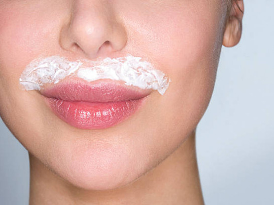 Mujer con crema depiladora para eliminar bigote