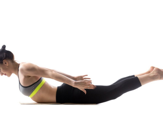 Mujer haciendo extensión de espalda como uno de los 5 ejercicios para marcar los hoyuelos de la espalda