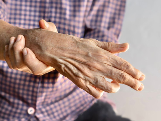 Hombre con rigidez en la mano para explicar los signos poco comunes de convulsiones que esconden una epilepsia