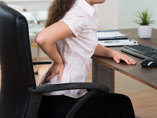 Mujer sentada con dolor de espalda 