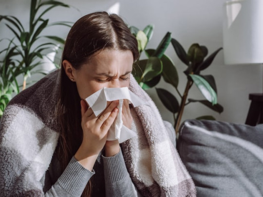 Mujer estornuda por alergia