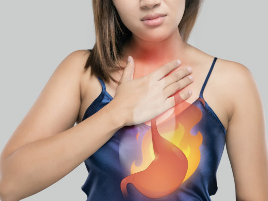 Mujer con ilustración representando molestias del estómago por gastritis con estómago en llamas