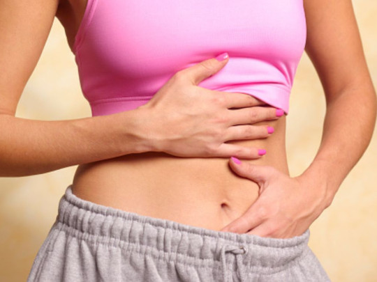 Mujer atlética mostrando el abdomen para ilustrar qué es la indigestión