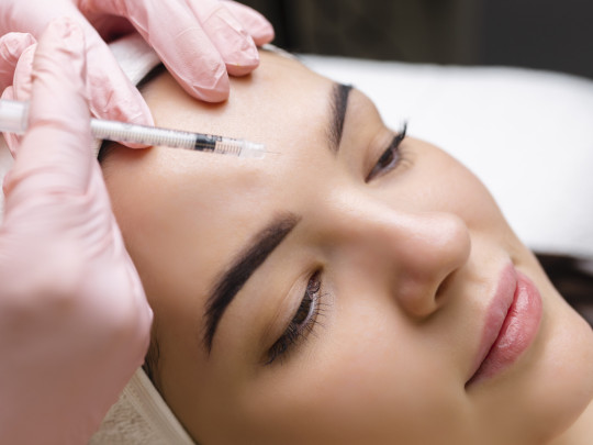 Mujer siendo sometida a Inyecciones de botox en la frente podrían modificar la actividad cerebral