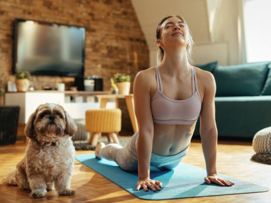 Mujer meditando junto a perro para explicar cómo bajar de peso meditando