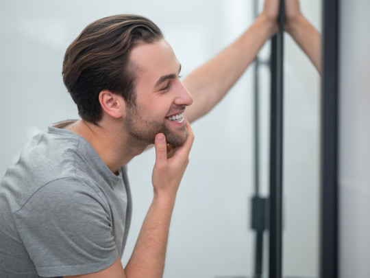 Hombre mirándose al espejo para explicar si el narcisismo es hereditario
