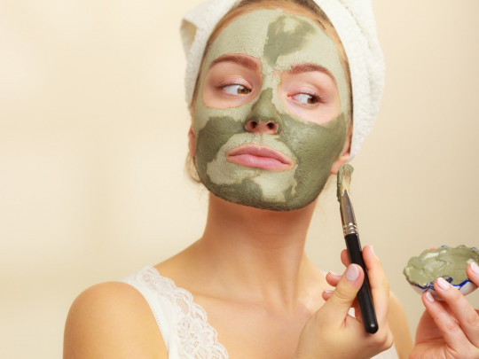 Mujer aplicando mascarilla de aloe vera en su rostro para desvanecer las manchas