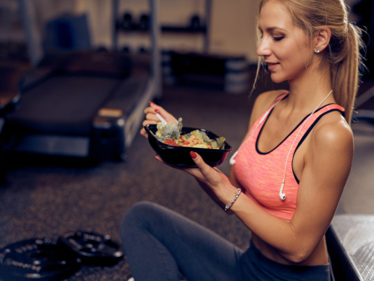 Mujer come post-entreno después de hacer ejercicio