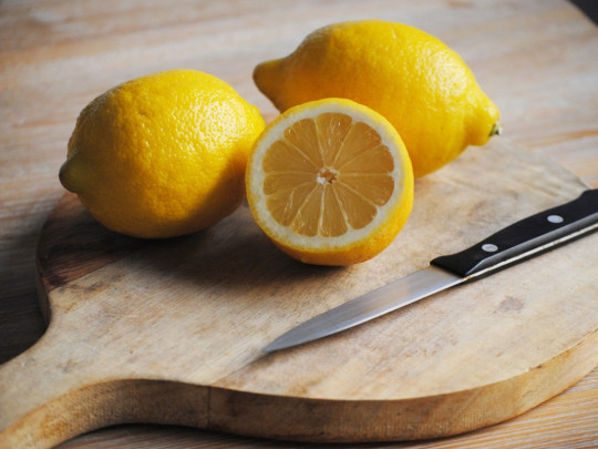 Joven parte limones para hacer el postre de yogurt con limón para bajar de peso. 