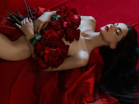 Mujer con flores sobre la cama despertando su deseo sexual femenino