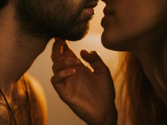Mujer besa a su pareja despertando el deseo sexual de ambos