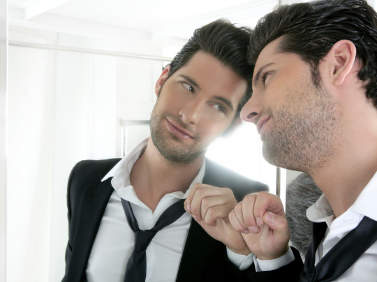 Hombre mirando fijo al espejo para explicar si el narcisismo es hereditario
