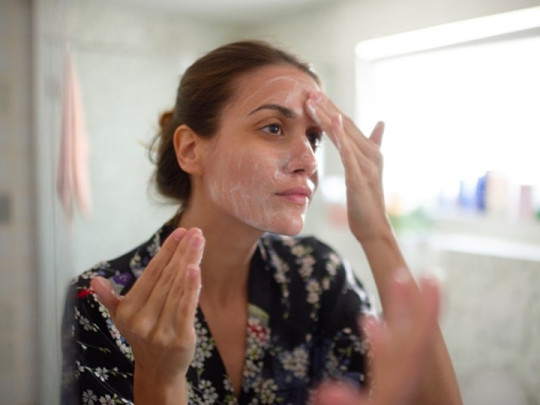 Mujer se lava el rostro para cerrar los poros de la piel