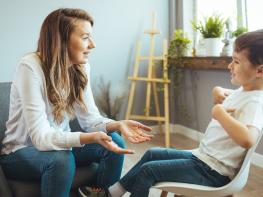 Terapeuta frente a niño le explica los tipos de autismo 
