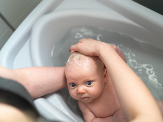 Bebé recien nacido recibiendo su baño