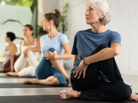 Personas en postura sobre tapete para ilustrar qué es yoga